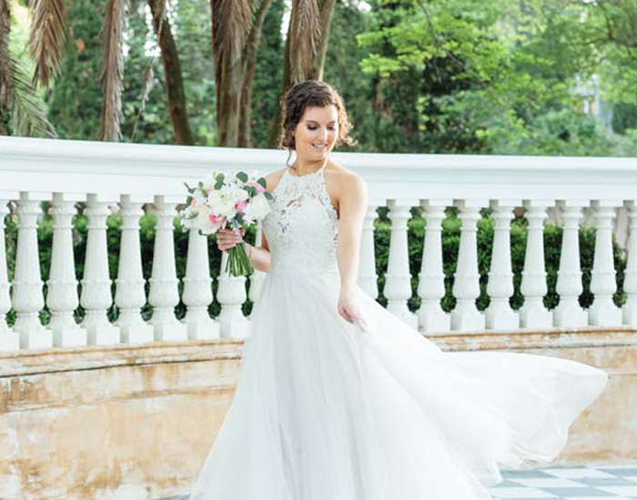Bride Standing in Front of White Marble Fence
